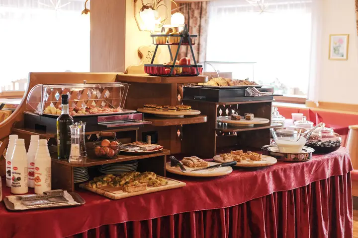 Il buffet della colazione sulla tovaglia rossa, dolce e salato